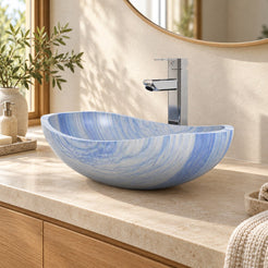 Spirit Azura blue quartzite oval vessel sink on a warm limestone counter above an oak vanity, front angled bathroom view