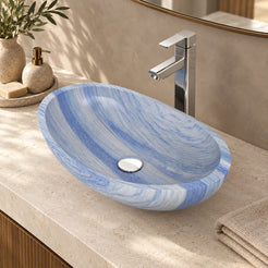 Elevated bathroom view of the Spirit Azura oval quartzite vessel sink showing blue-white mineral bands and its circular drain cover