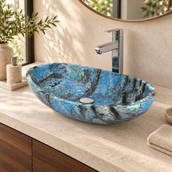 Spirit Danube shallow oval blue quartzite vessel sink on a pale counter above a walnut vanity, angled bathroom view