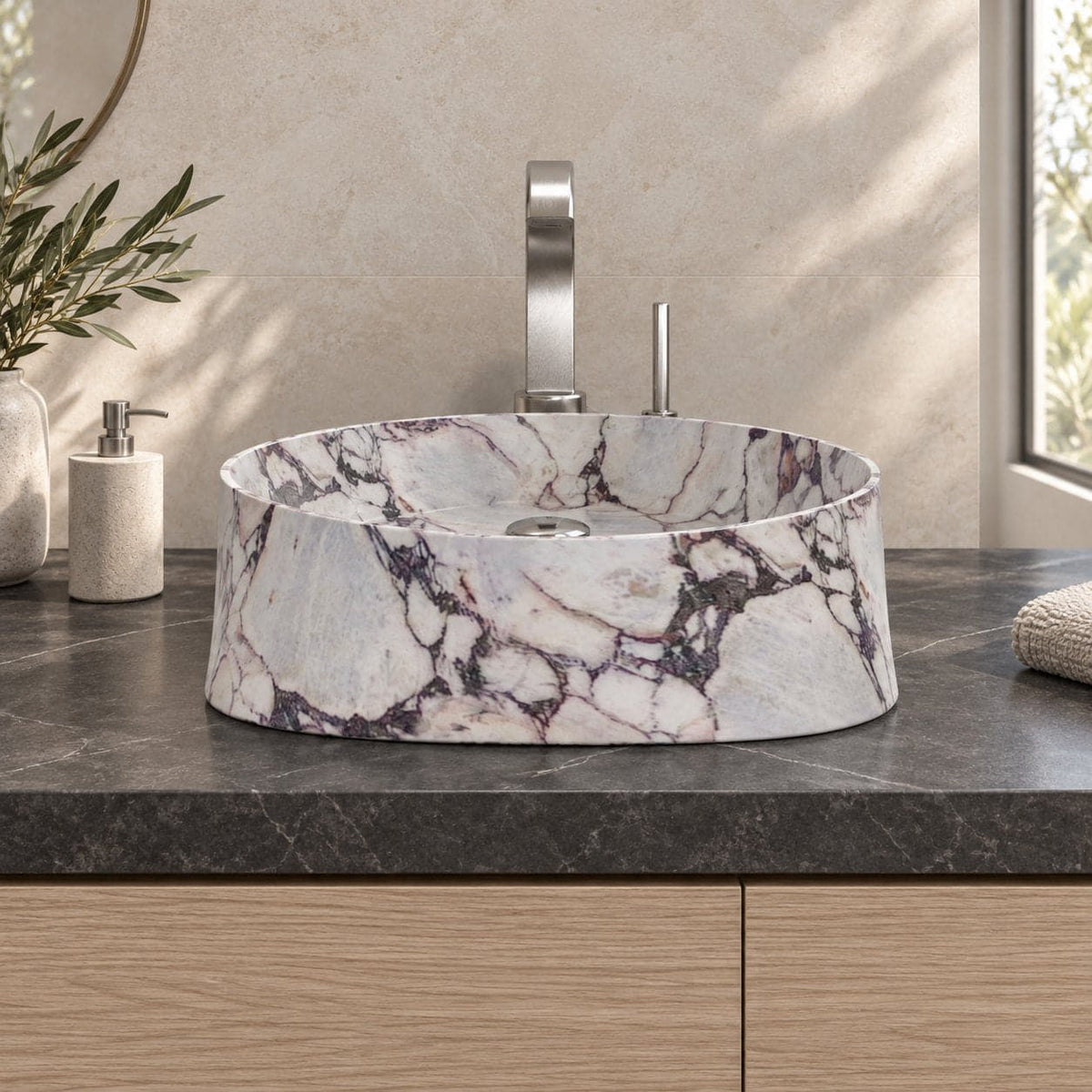 Illustrative low frontal bathroom lifestyle of the Safira Calacatta marble vessel sink with a rounded triangular form