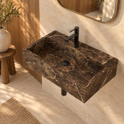 Elevated view of Tiarra Marroca marble wall-mounted sink in a warm oak bathroom, showing its complete rectangular basin and black circular drain