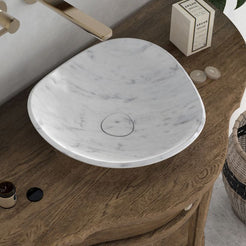 High-angle bathroom view of the Sita Carrara marble specialty sink showing its three-sided bowl and circular drain cover
