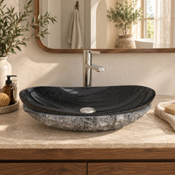 Soraya Oval Neroco Stone vessel sink from the front in a warm walnut bathroom, showing its polished black basin and rough gray exterior.