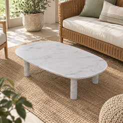 SquareCurve Carrara marble coffee table viewed from an elevated diagonal angle in a sunroom.