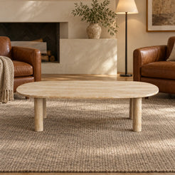 Low front view of the SquareCurve Italian Classico travertine coffee table in a leather-chair reading lounge, showing its thin top and four stone legs.