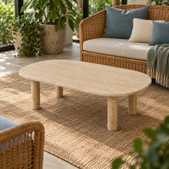 Elevated view of the SquareCurve Italian Classico travertine coffee table in an indoor conservatory, showing its rounded rectangular top and four cylindrical supports.