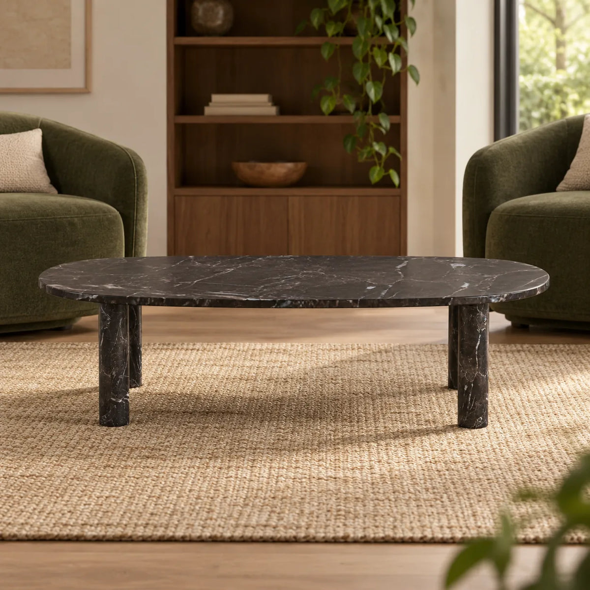 Low front view of the SquareCurve Spanish Dark Emperador marble coffee table in a moss-green-chair reading lounge, showing its thin top and four stone legs.