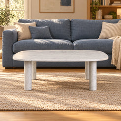 SquareSoft Carrara marble coffee table in front of a blue linen sofa, shown from a low front view