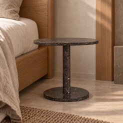 Low frontal view of the SquareSoft Dark Emperador marble side table beside a timber bed.