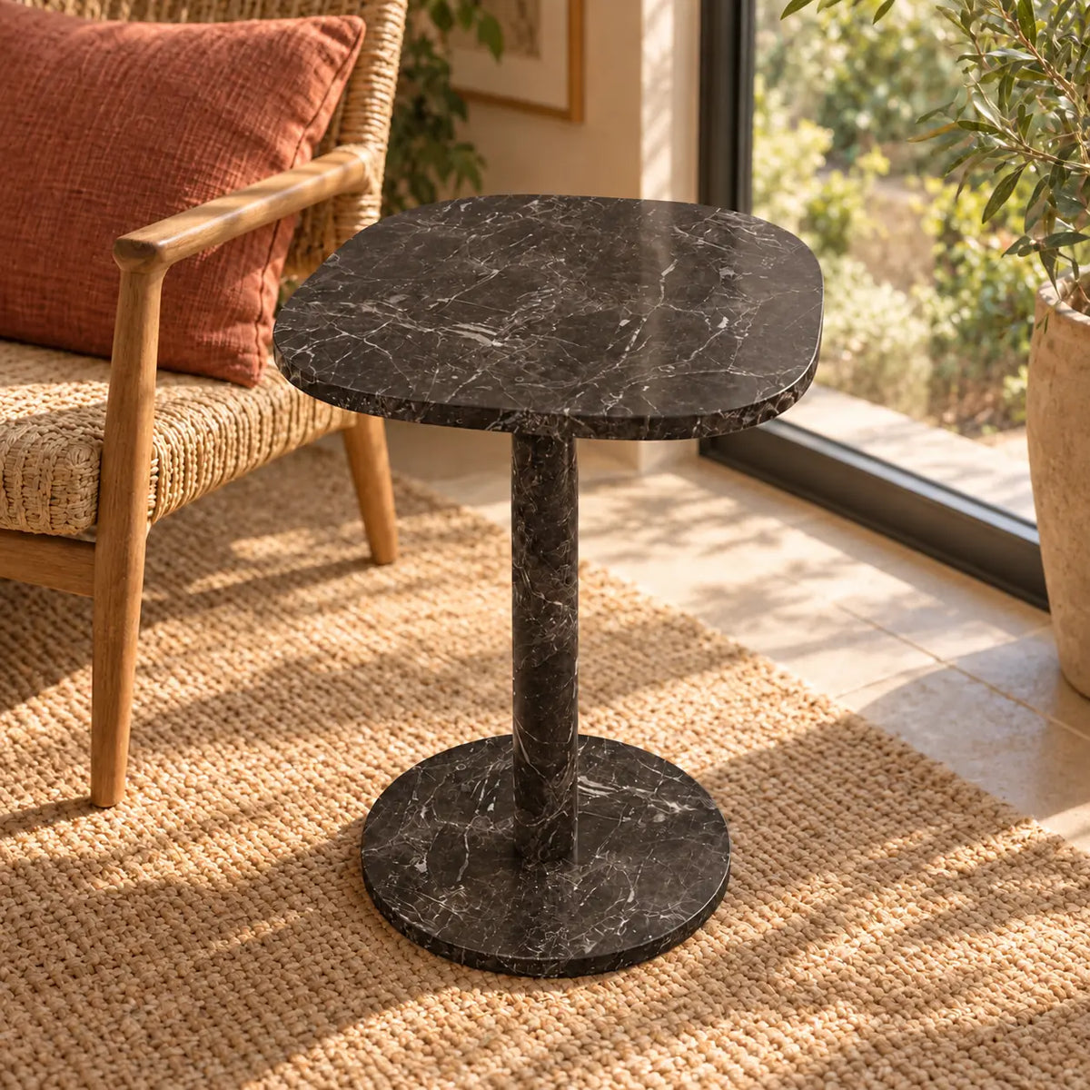 Elevated view of the SquareSoft Dark Emperador marble side table in a window-side reading nook.