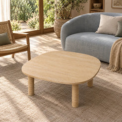 Elevated view of the SquareSoft travertine coffee table in a garden-facing reading room, highlighting its rounded-square tabletop.