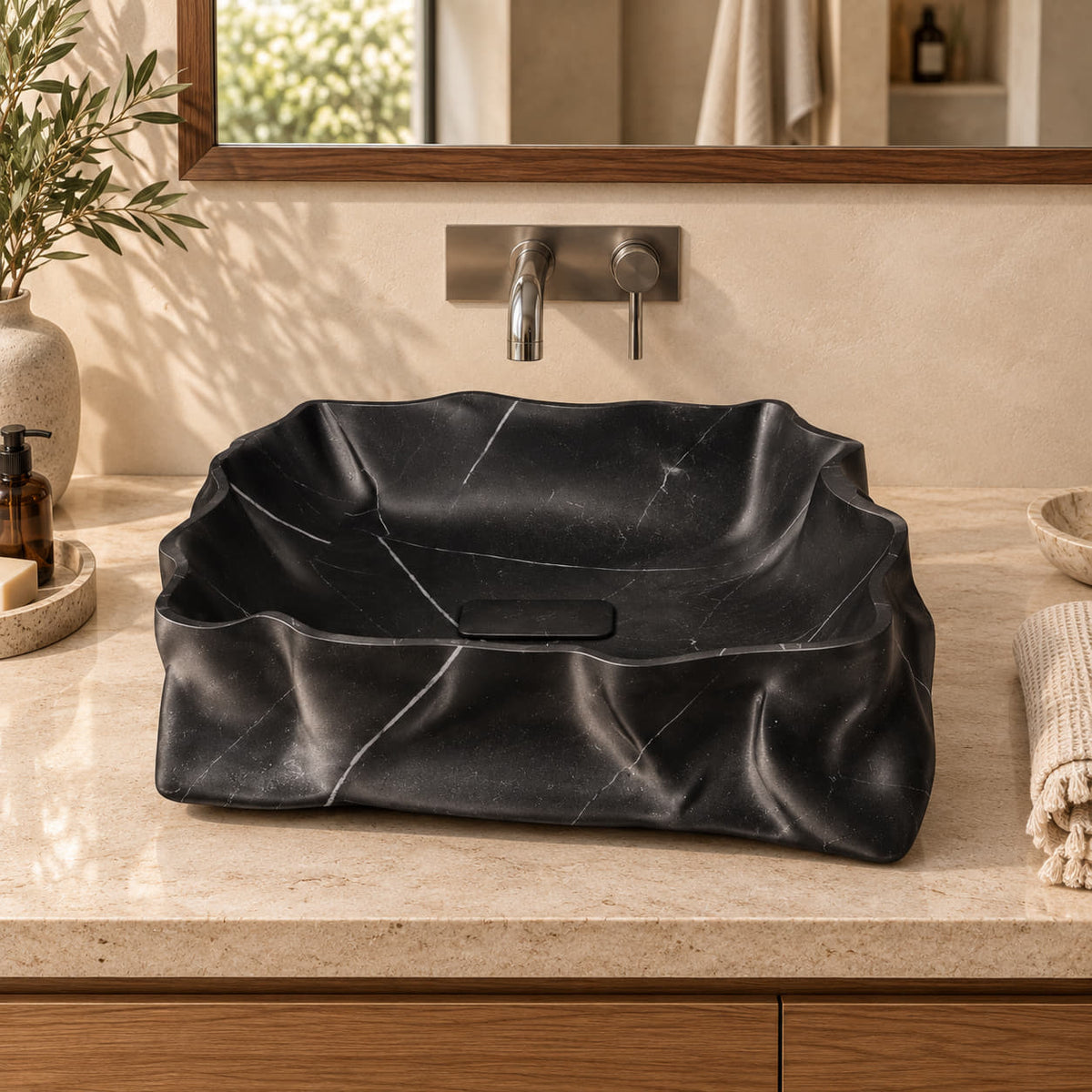 Srusti Portoro Marble vessel sink from the front in a warm oak and cream bathroom, with sculpted folded stone walls and a rectangular stone drain cover.