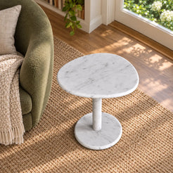 Elevated view of the SwanEgg Carrara marble side table in a garden-facing reading room.