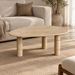 SwanEgg Italian Classico travertine coffee table with a thin oval top and three cylindrical legs in a warm linen-sofa living room.