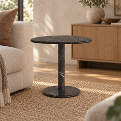 SwanEgg Dark Emperador marble side table with an oval top and circular base in a warm sofa seating area.