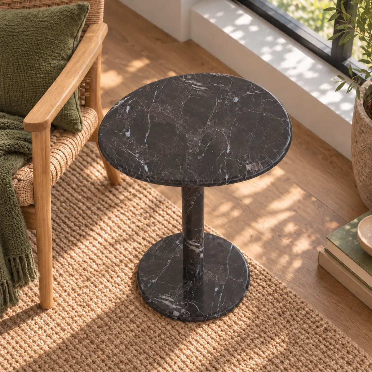 Elevated view of the SwanEgg Dark Emperador marble side table in a garden-window reading corner.
