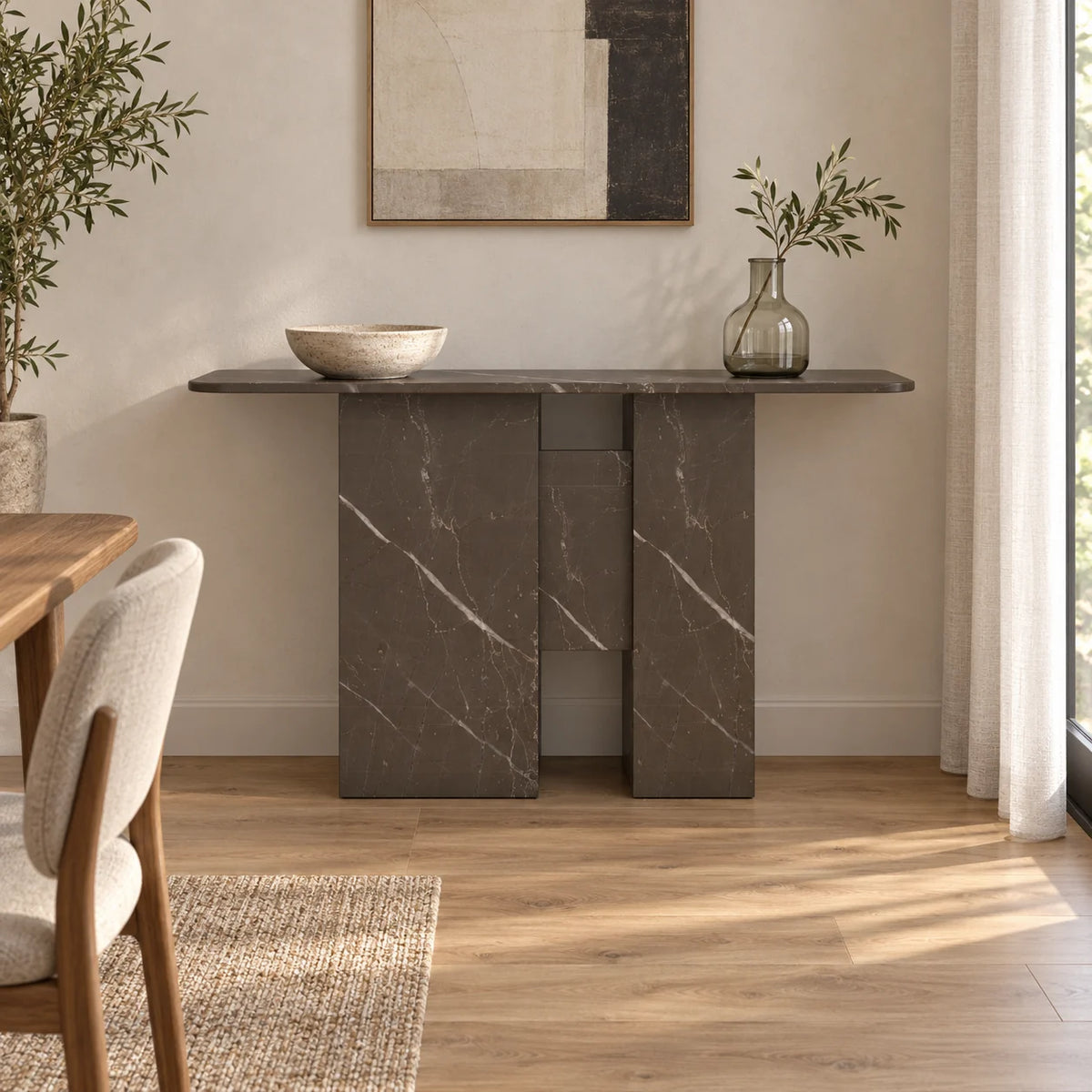Front view of the Thalia Bulgarian Gray marble console along a dining-room wall, with unequal-width stone supports and open spaces above and below its central panel