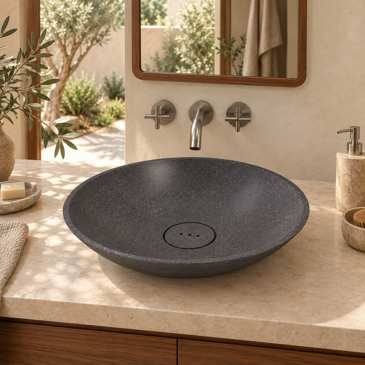 Vinita Neroco Stone shallow round vessel sink from the front in a warm walnut courtyard bathroom, with a matching three-hole stone drain cover.