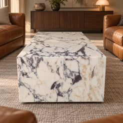 ViolaPlinth Calacatta Viola marble coffee table in a leather-chair lounge, shown from a raised short-end view