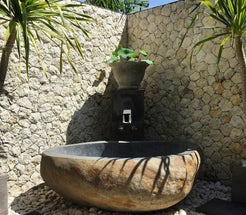 Yitta Filetto Cobble Stone natural stone bathtub installation reference from the supplied project archive, in an outdoor stone-walled setting