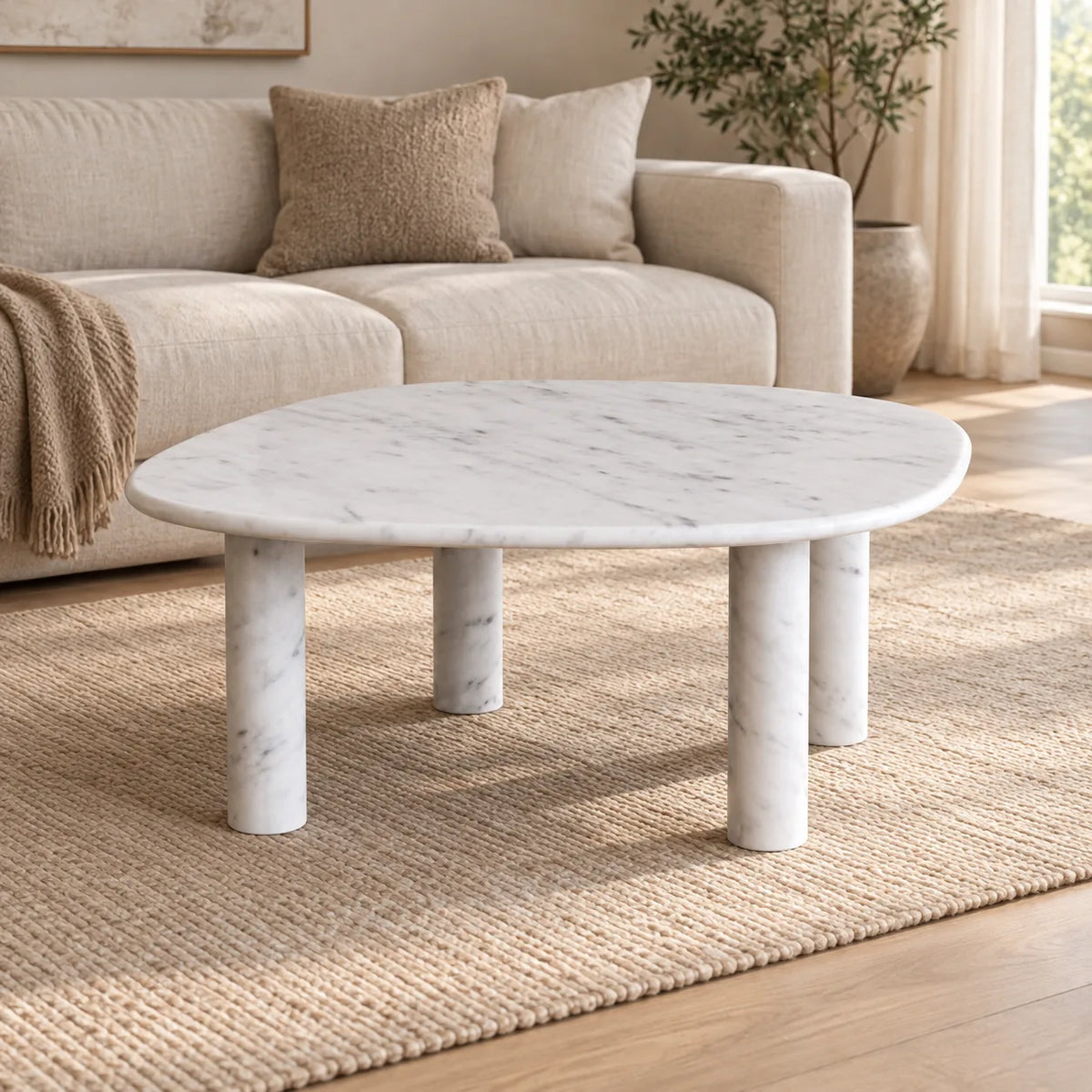 ZenPebble Italian Carrara marble coffee table with a thin soft-square top and four cylindrical stone legs in a warm linen-sofa living room.