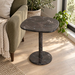 ZenPebble Dark Emperador marble side table in a window reading corner, shown from an elevated oblique view